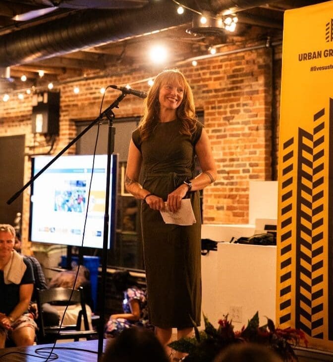 Woman standing on stage at corporate event at Nashville event venue, Room With A View. Photo by Gina DiMaio.