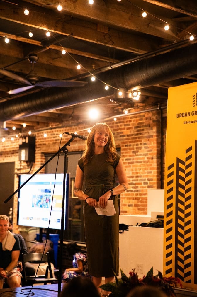 Woman standing on stage at corporate event at Nashville event venue, Room With A View. Photo by Gina DiMaio.